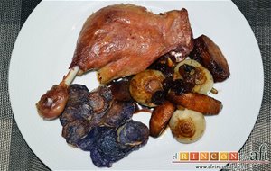 Confit De Pato Con Cebollitas Francesas, Manzanas, Pasas Y Piñones Caramelizados Y Papas Chips Azules