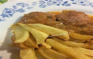 Tortitas De Carne En Salsa De Cebolla Acompañadas De Patatas Fritas 
