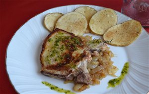 Chuletas Sobre Cama De Cebolla Y Guarnición De Patatas
